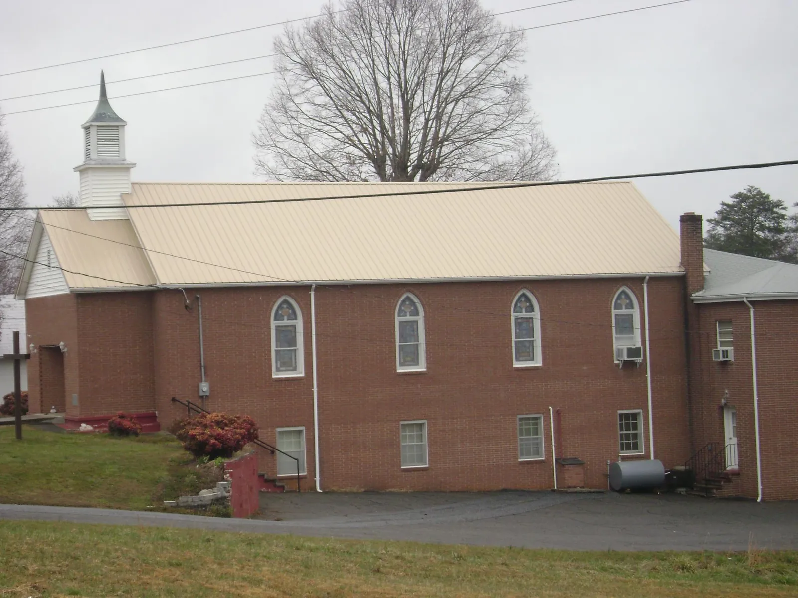New tan metal roof on a brick church with a white steeple in Saint Petersburg