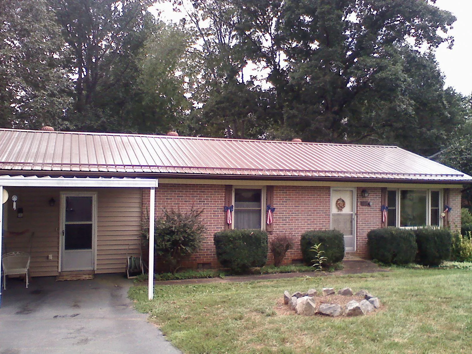 Bronze metal roof and carport on a brick ranch home — Roof Repair work by our crew in Saint Petersburg